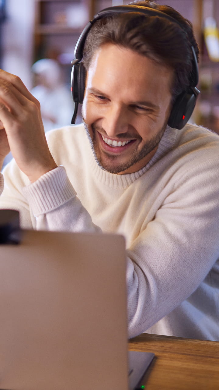 Man with Jabra Evolve2 headset in video conference in home office – clear voice quality during remote calls