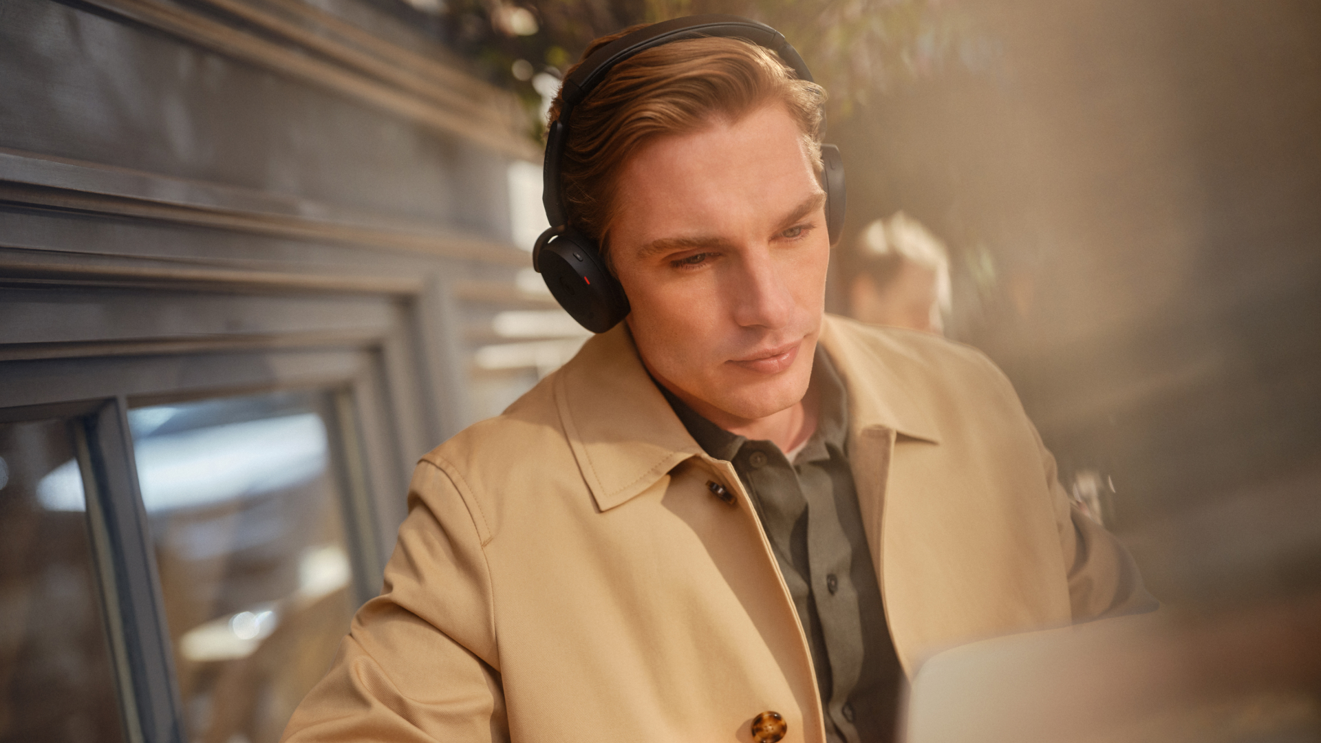 Person wearing Jabra Evolve3 65 Flex headset while working on a laptop