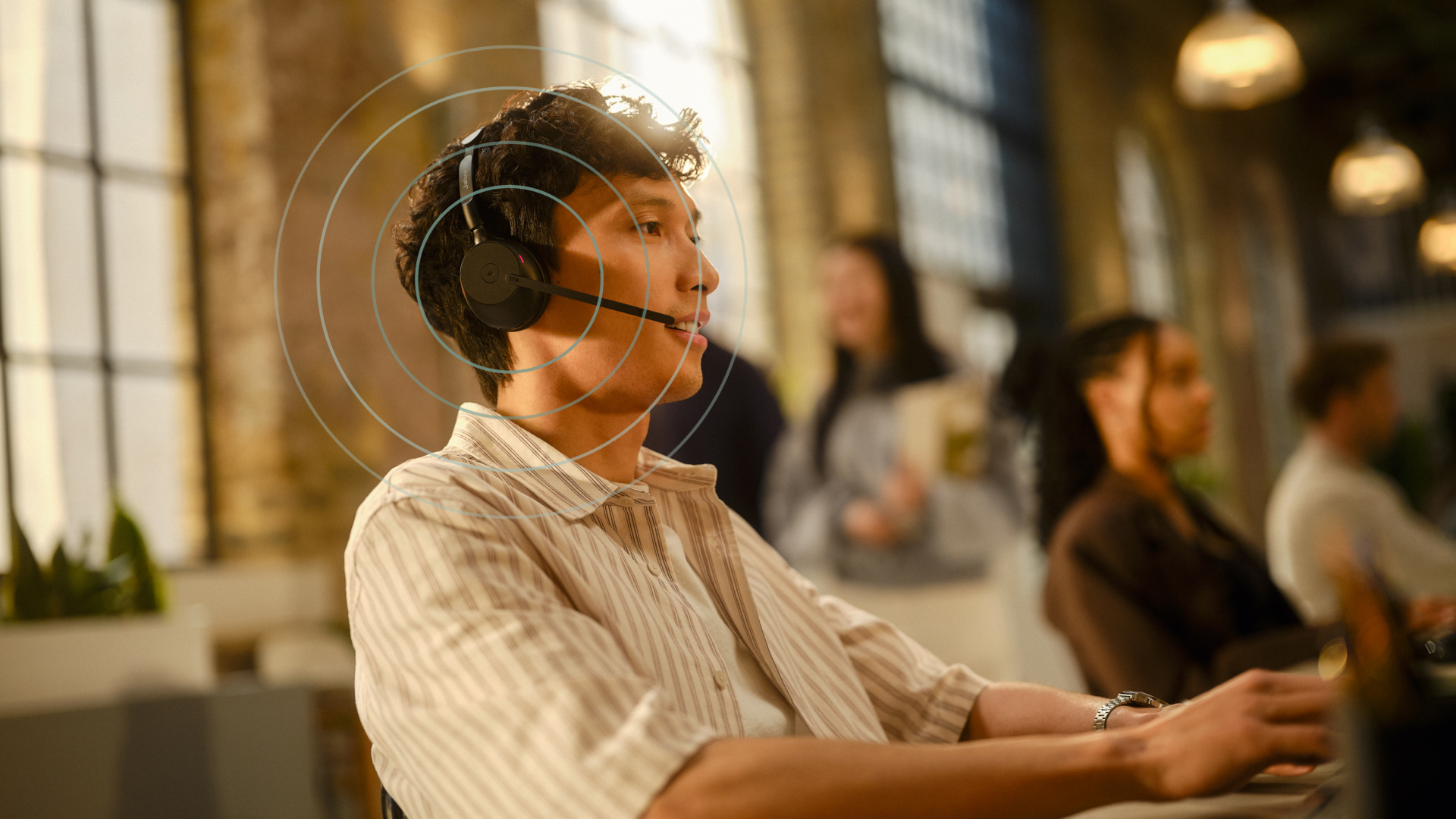 Person wearing Jabra Evolve3 65 headset while working at a desk