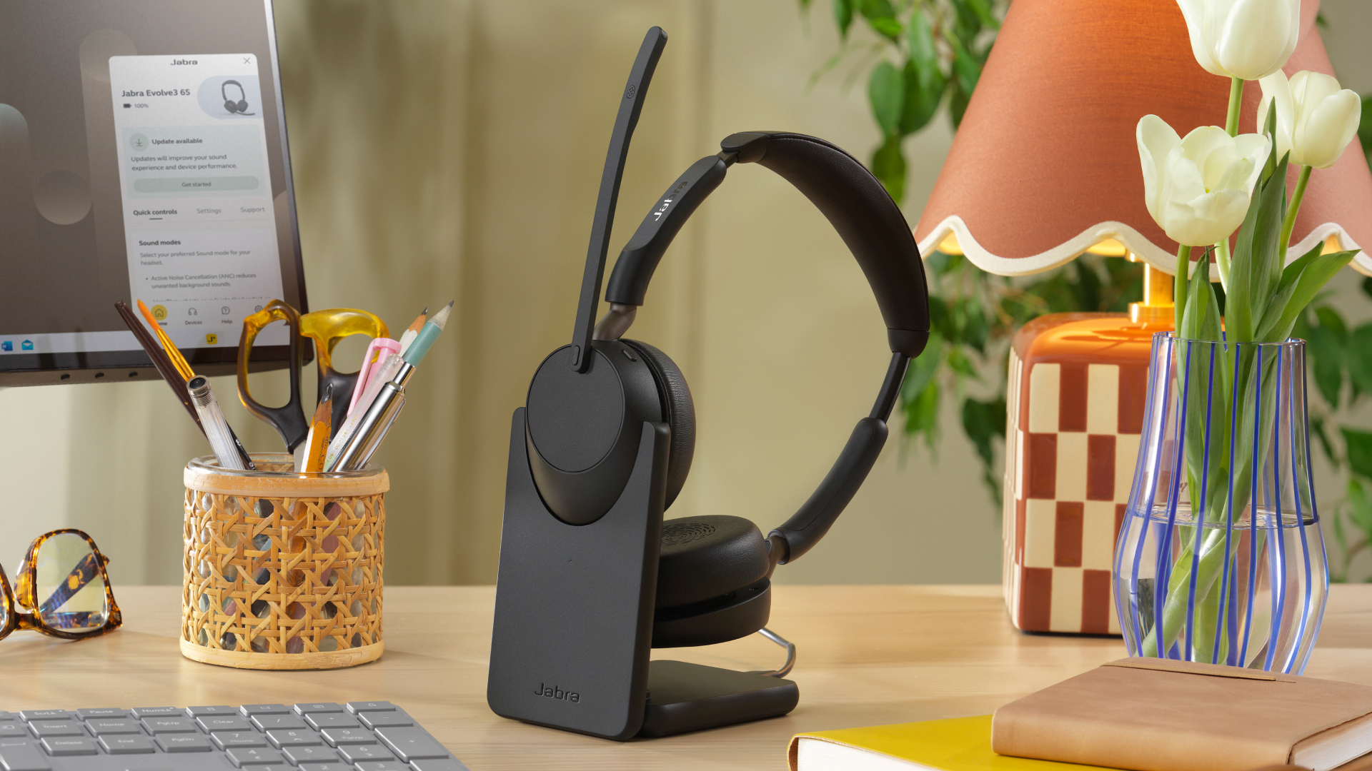 Jabra Evolve3 65 headset on a charging stand in an office workspace