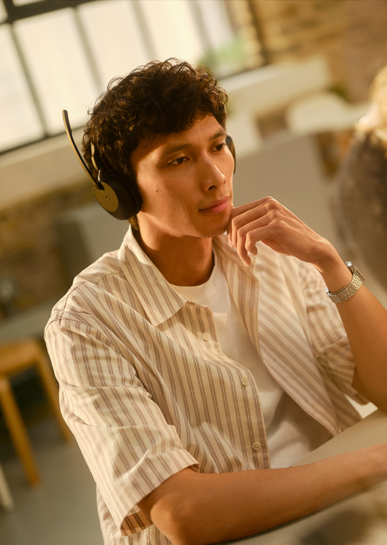 Person wearing Jabra Evolve3 65 headset while working at a desk