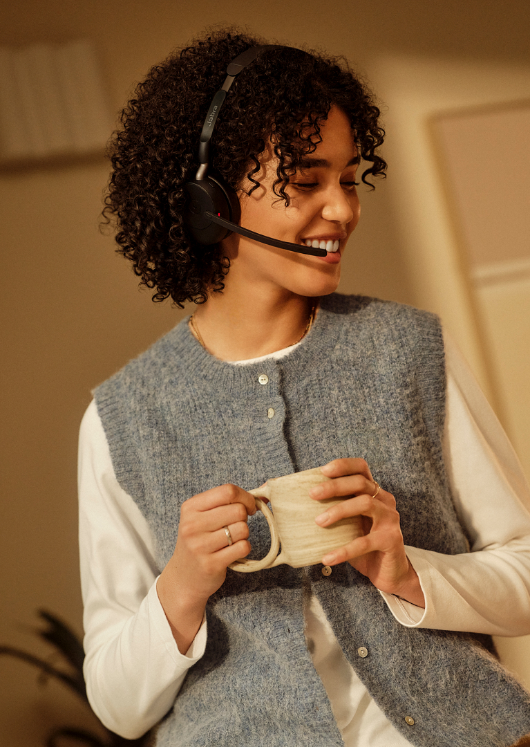 Person holding Jabra Evolve3 65 headset in an indoor setting